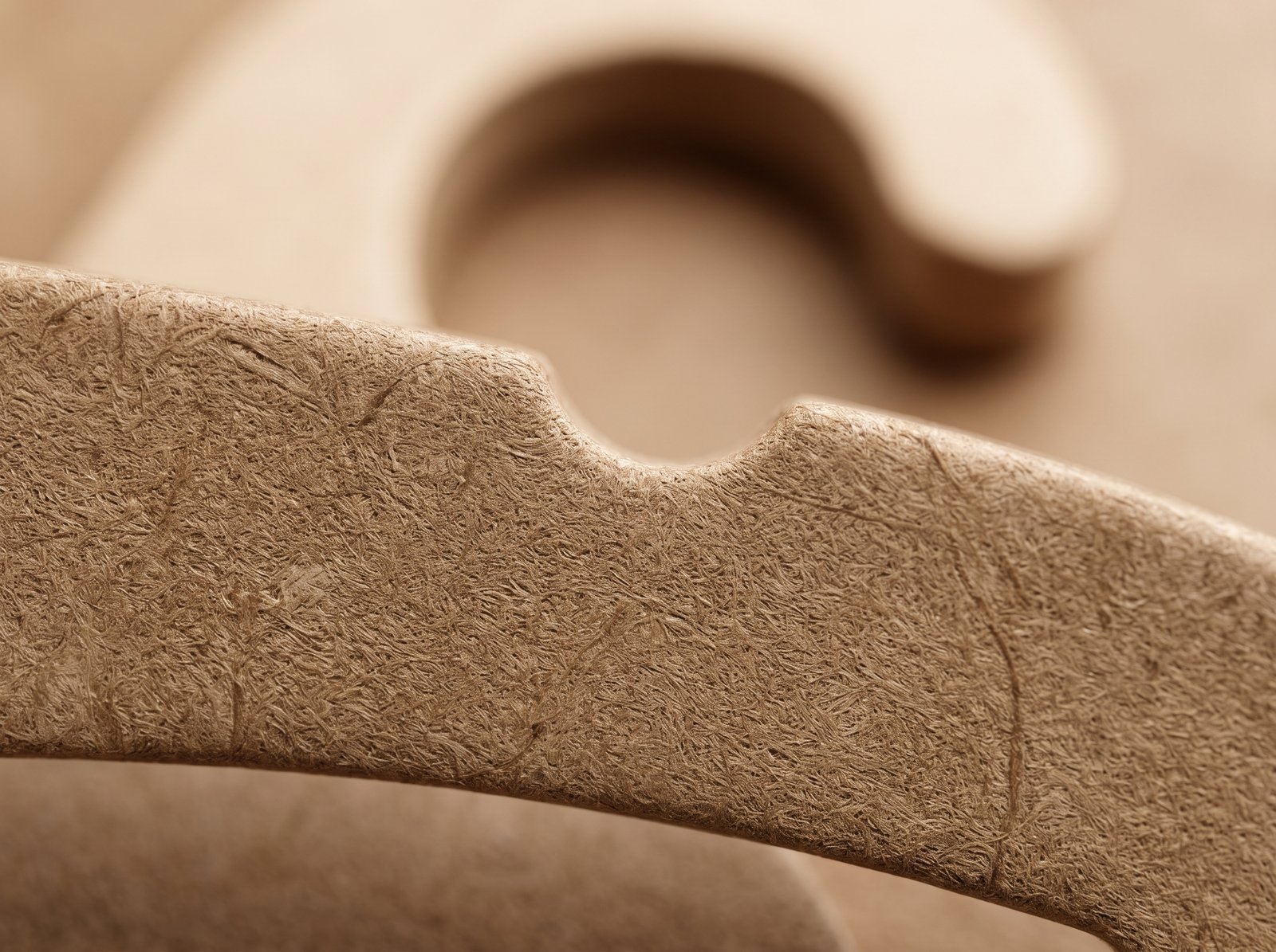 Primer plano macro de la textura lisa y densa del cartón comprimido tipo madera, mostrando su calidad premium sin corrugado visible.