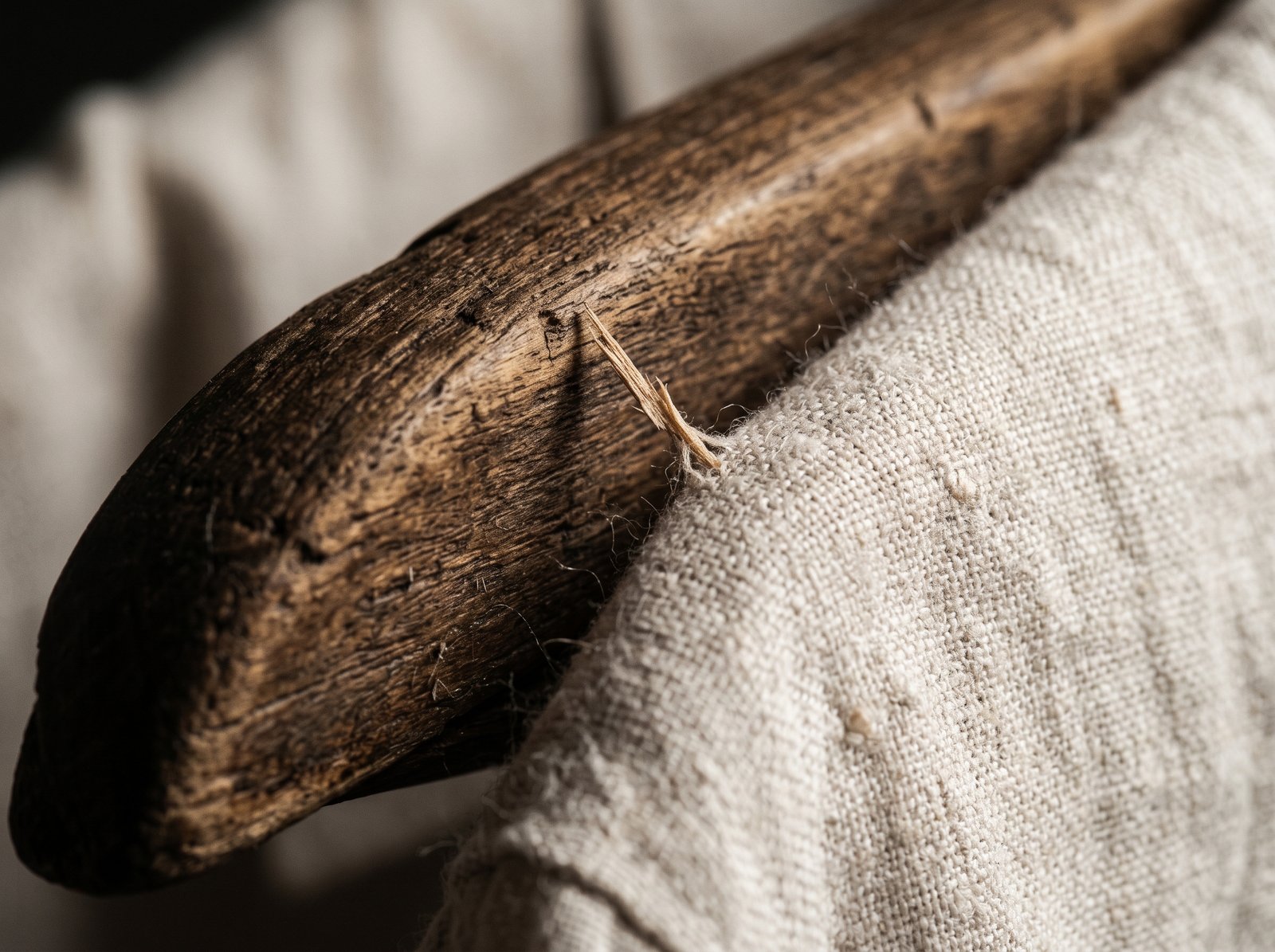 Primer plano de un gancho de madera para ropa con astillas que pueden dañar telas delicadas.